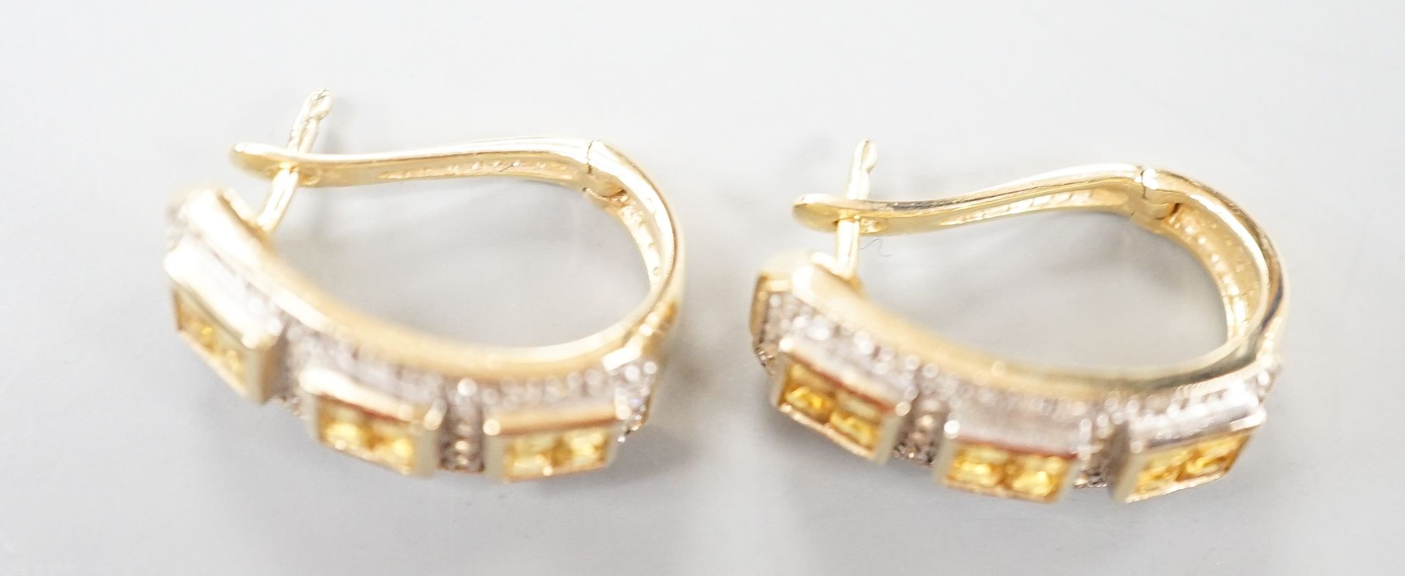 A modern pair of 14k yellow metal, diamond chip and triple cluster yellow sapphire? set half hoop earrings, 19mm, gross weight 6.9 grams.